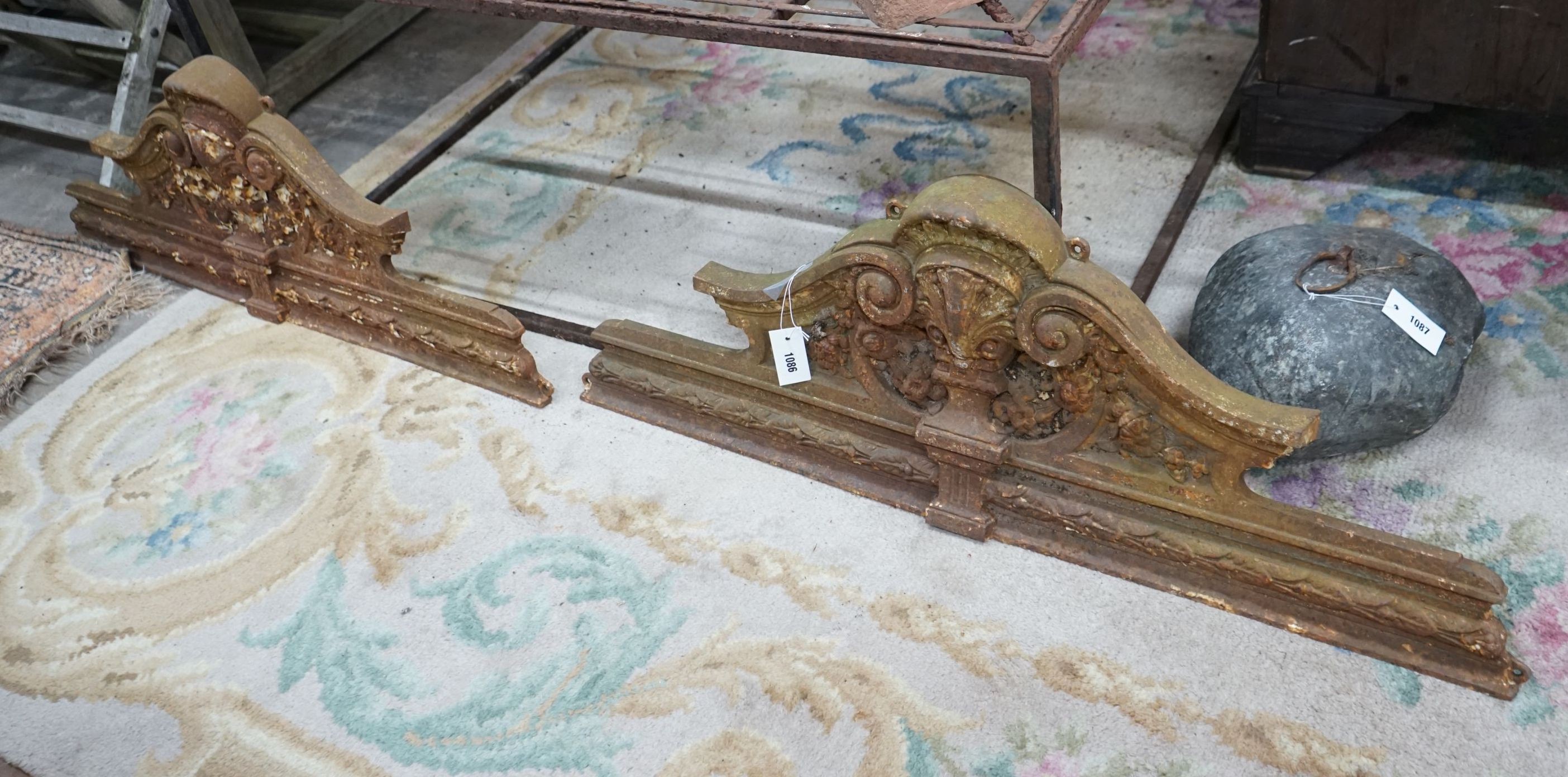 A pair of Victorian cast iron shell and scroll door pediments, each width 108cm, height 38cm